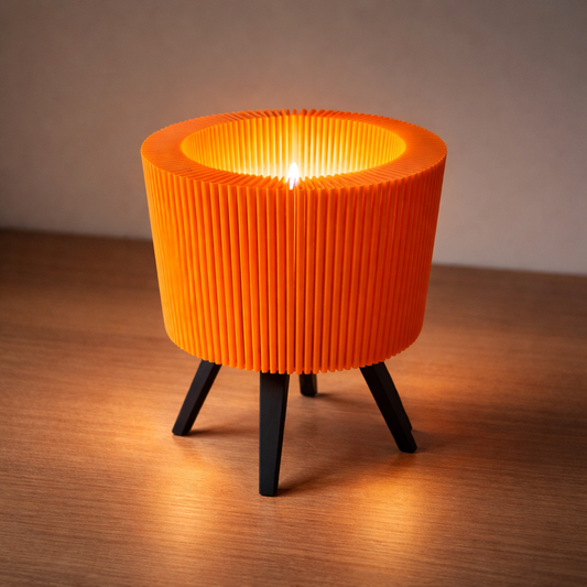Orange ribbed lamp with black legs on a wooden surface