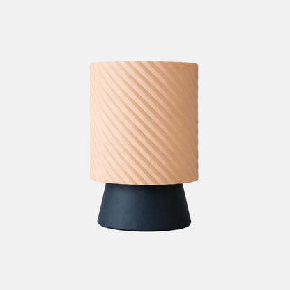 Table lamp with a beige textured shade and navy base on a light gray background