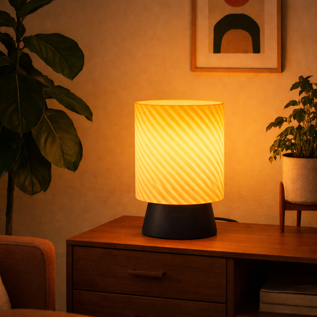Decorative lamp on a wooden surface with plants and a framed picture in the background