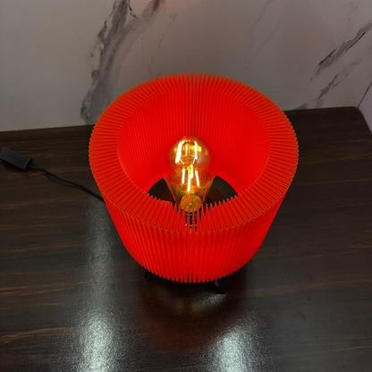 Red lamp with a visible light bulb on a dark surface