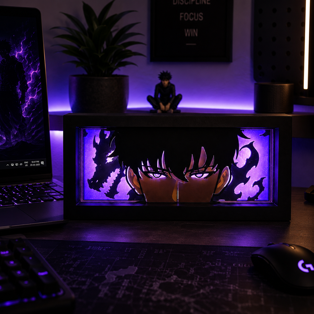 Desk setup with a laptop, keyboard, mouse, and decorative light box featuring anime design.