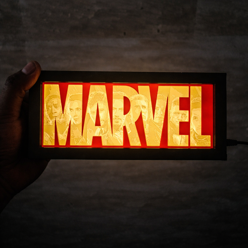 Marvel logo light box held in a hand against a dark background