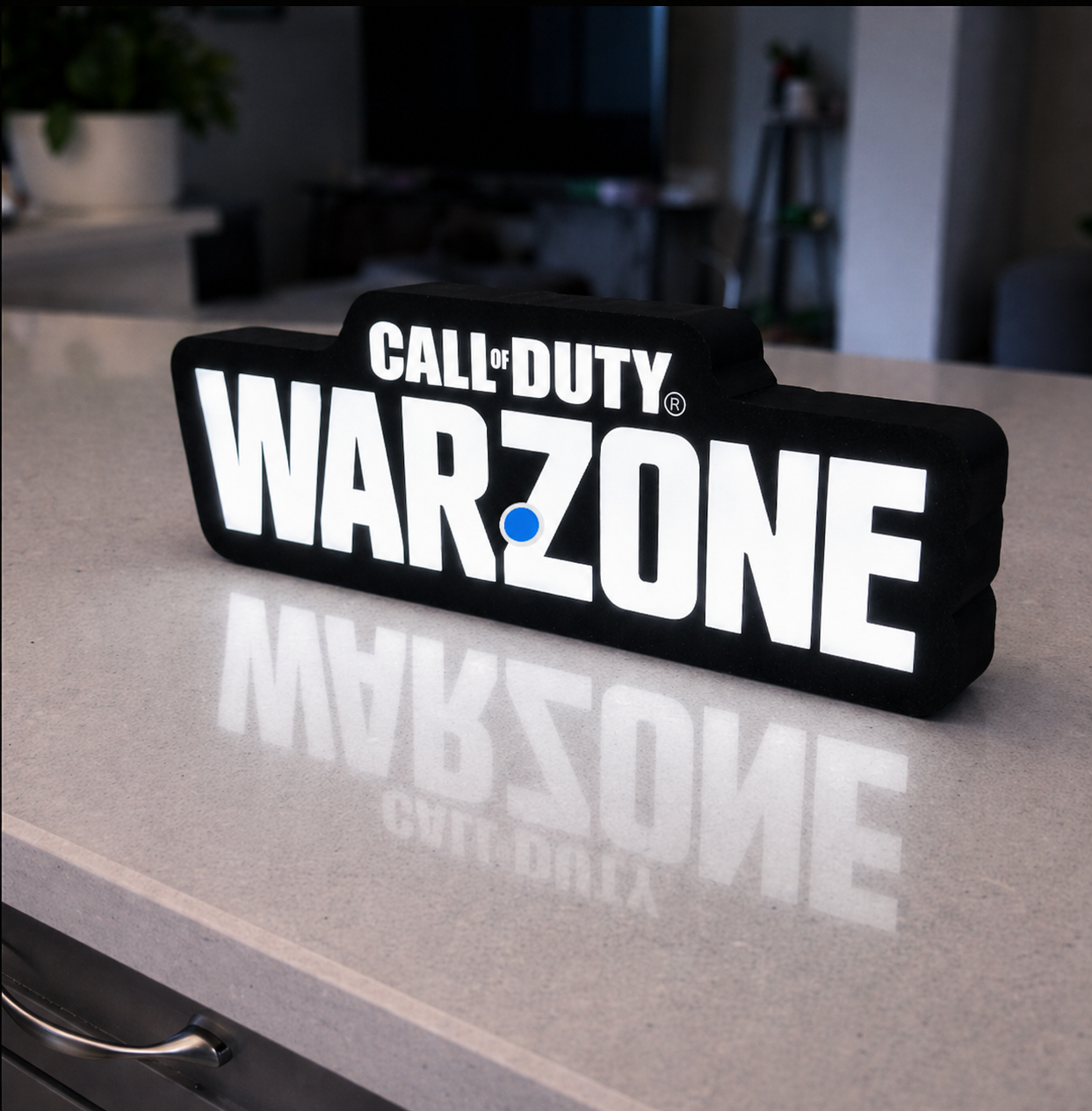 Call of Duty Warzone light box on a reflective surface with a blurred indoor background