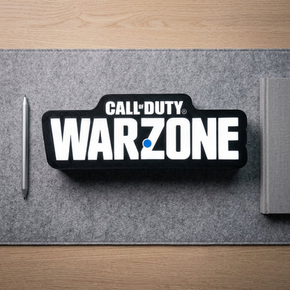Call of Duty Warzone logo on a desk mat with a pen and notebook.