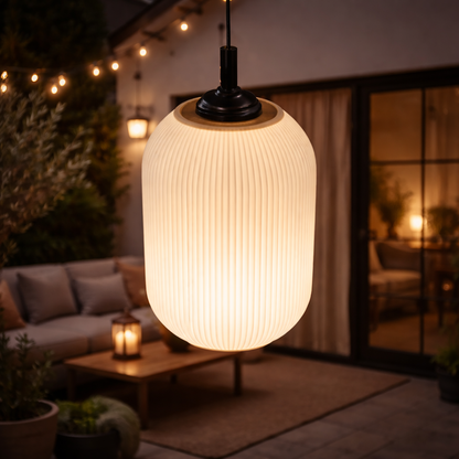 Outdoor pendant light in a cozy patio setting with string lights and a couch.