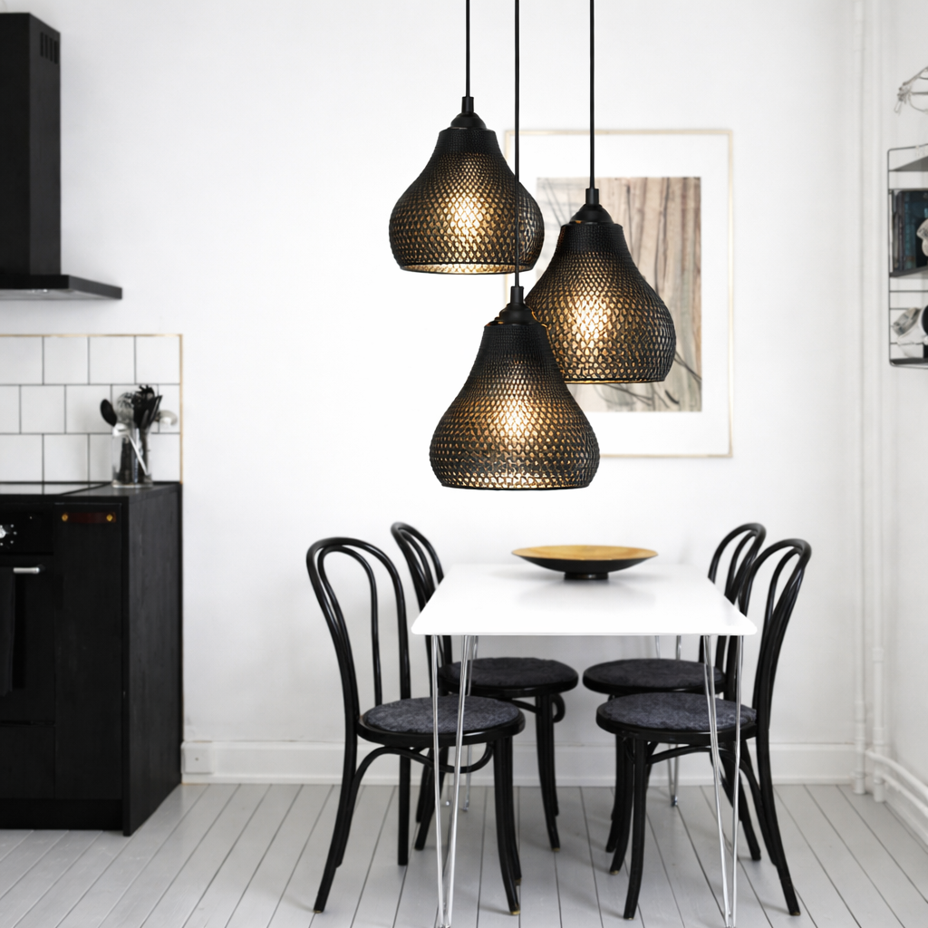 Dining area with black pendant lights, chairs, and a table against a white wall.
