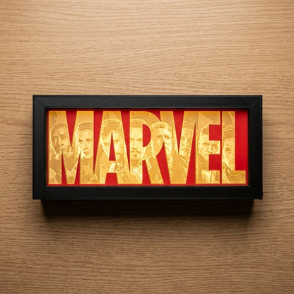 Marvel logo with character faces in a black frame on a wooden background