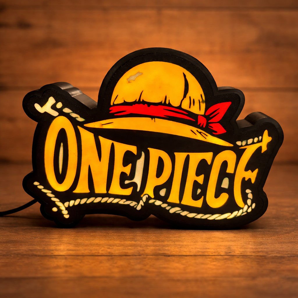 One Piece-themed lamp with a yellow hat and red ribbon on a wooden surface.