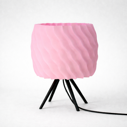 Pink lampshade on a black metal stand against a white background