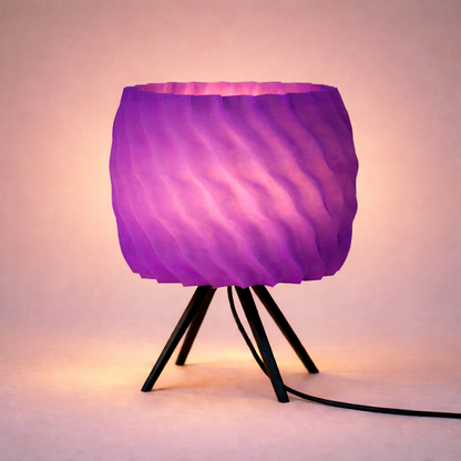 Purple lamp with a wavy texture on a tripod stand against a soft pink background