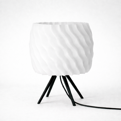 White textured lampshade on a black metal stand against a white background
